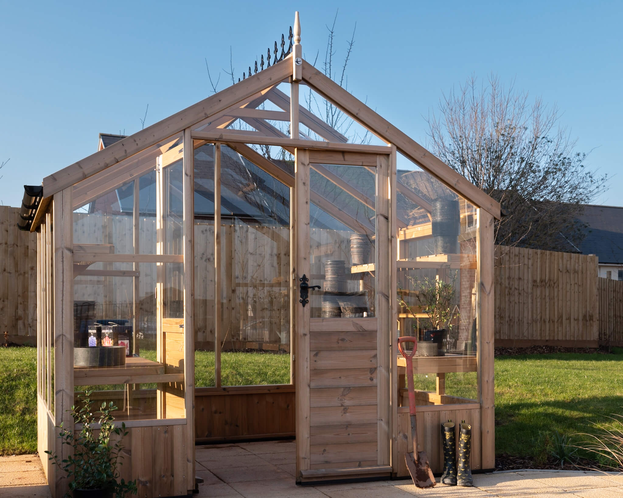 A wooden greenhouse. Bright clear blue skies.