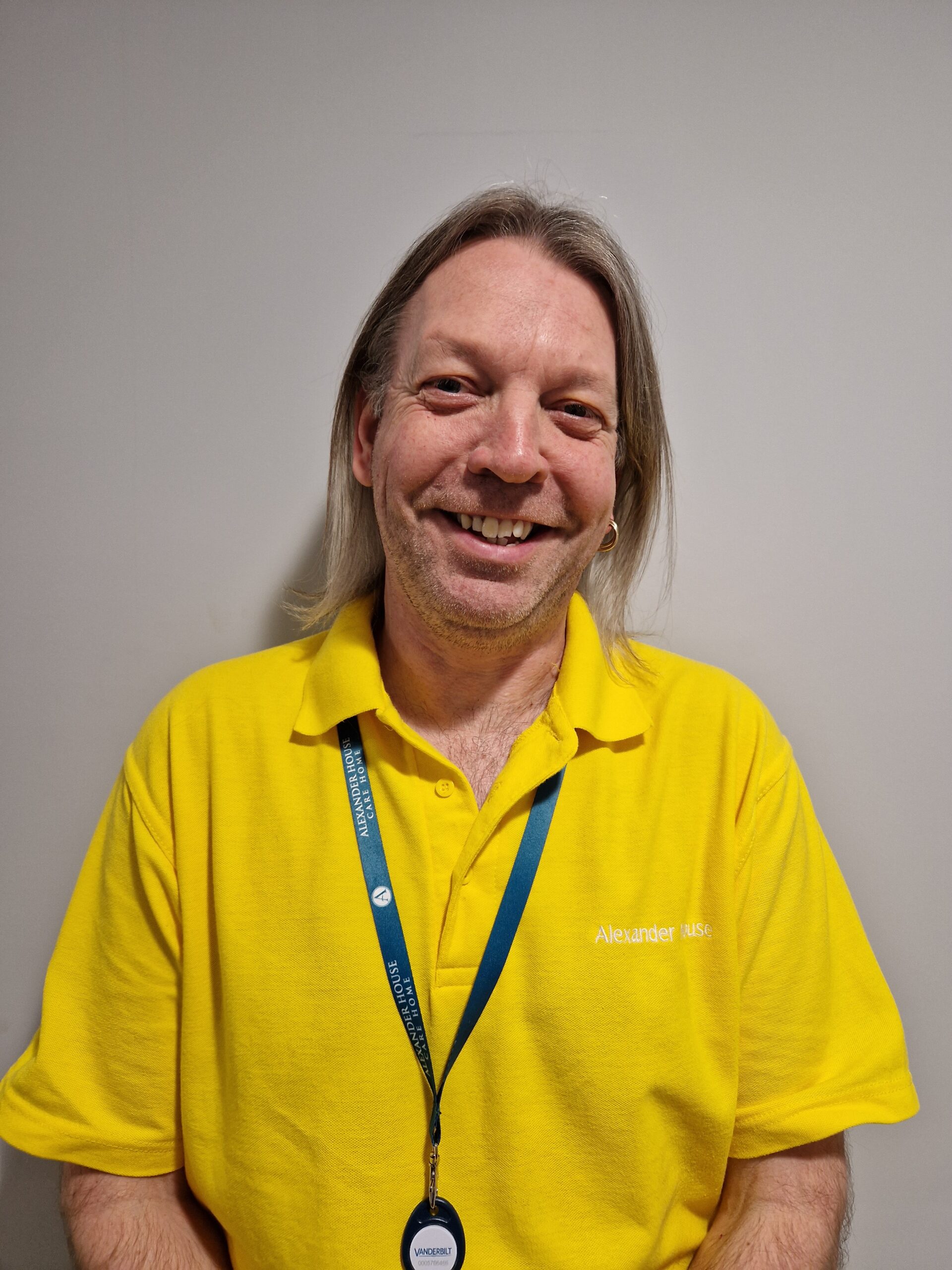 A team member in a yellow polo top and blue lanyard.