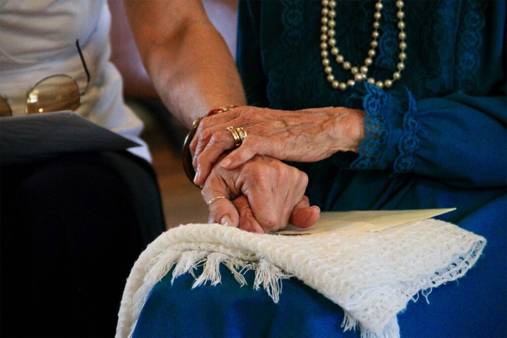 A loved one holds a residents hand