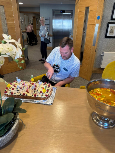home manager cutting his birthday cake