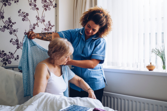 Carer dressing resident